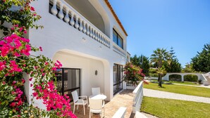 A white building with a balcony, a table, and chairs. - Villa Vale a Pena, for up to 40 people, near Carvoeiro.  (Carvoeiro)