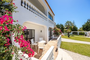 Relax on the balcony with lush greenery and a table for two.