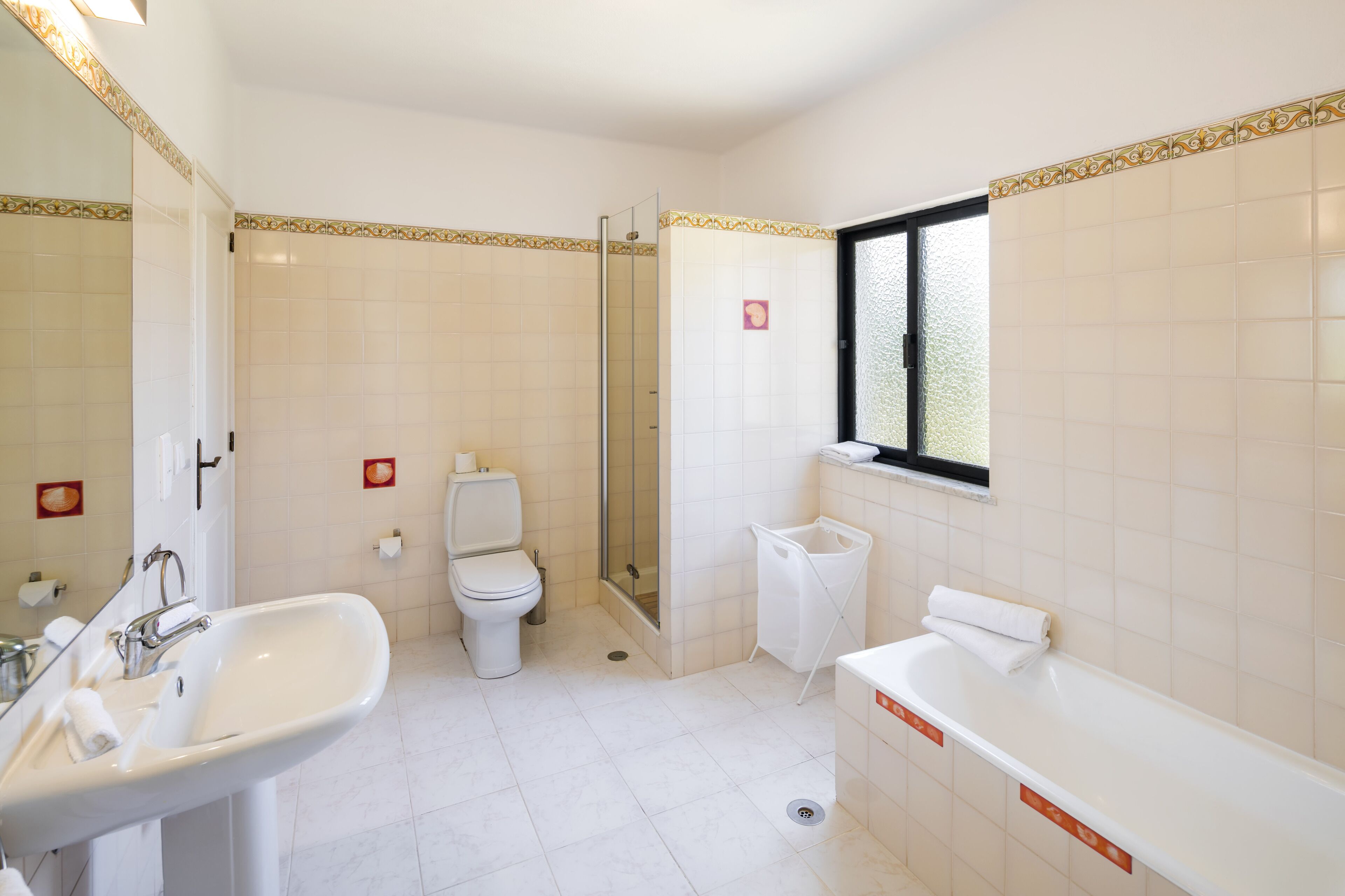A bathroom with a sink, toilet, shower, and bathtub.