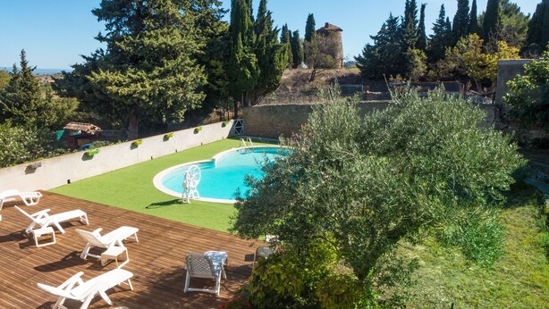 A pool area with a wooden deck, lounge chairs, and a clear blue pool. - Nice confortable cottage with large pool with views in minervois  (Montbrun-Des-Corbières)