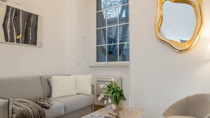 A modern living room with a grey sofa, a coffee table with books, a potted plant, and a unique mirror. - Marvellous 3 bed / 2 bath apt near Vatican  (Roma)