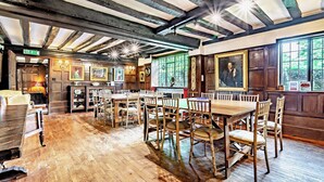 A traditional inn with wooden floors, exposed beams, and a dining area with wooden tables and chairs. - Large Tudor Manor House with Private Jacuzzi & Indoor Pool, Sleeps Max 20. (Hailsham)