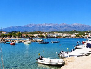 A marina with boats docked, clear blue water, and a mountainous backdrop. - Private pool, & large garden - 100m from beach, tavernas & shops in Almyrida. (Almyrida)