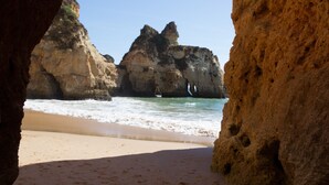 Une plage parsemée de formations rocheuses, offrant une vue dégagée sur l’océan.
