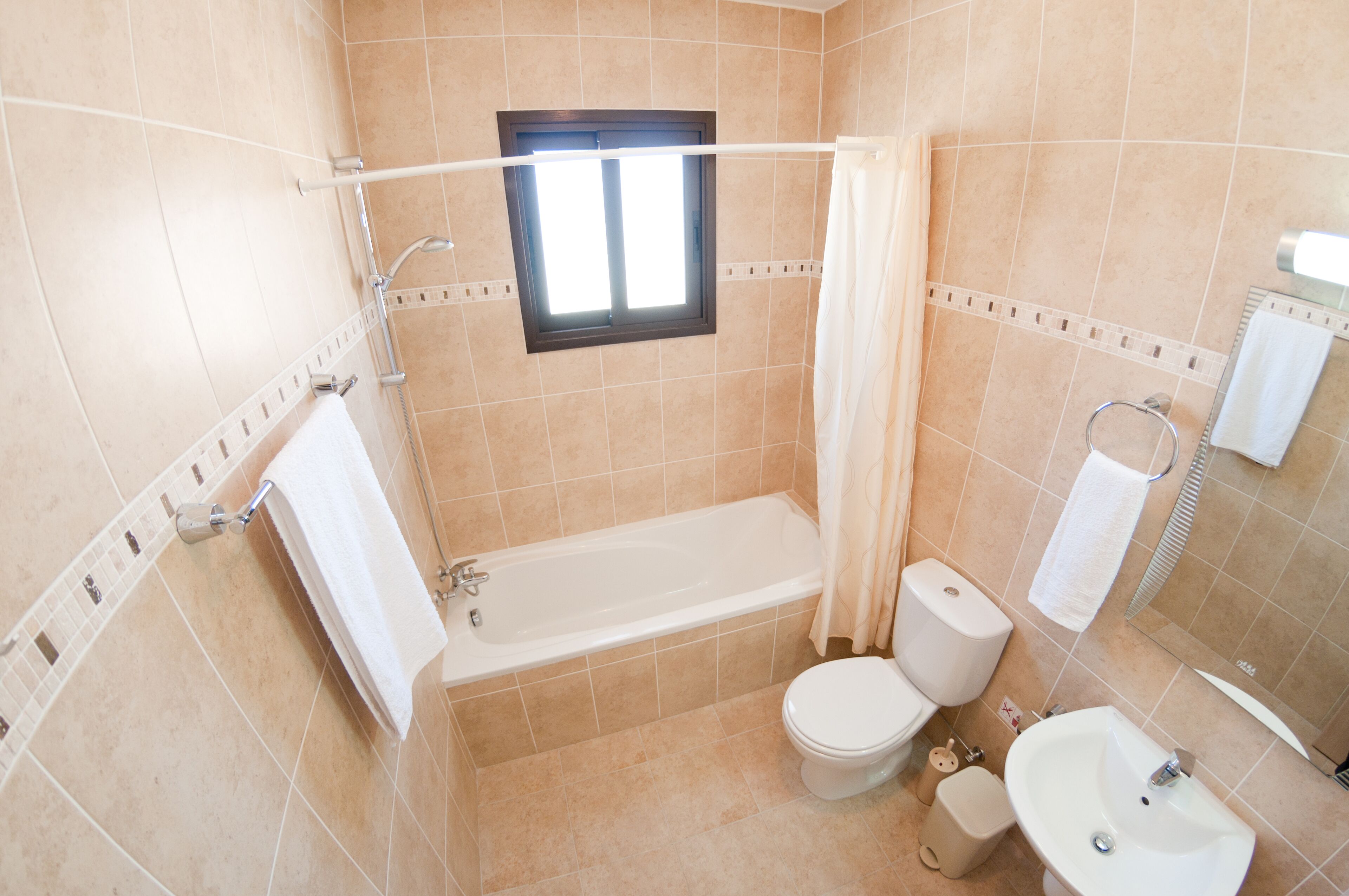 Un baño con bañera, inodoro y lavabo.
