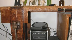 Een houten kast met een desktopcomputer en decoratieve planten.