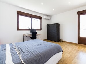 A bedroom with a bed, a desk, a chair, a wardrobe, and a window. - Exclusive Villa with garden and pool (Melegís)