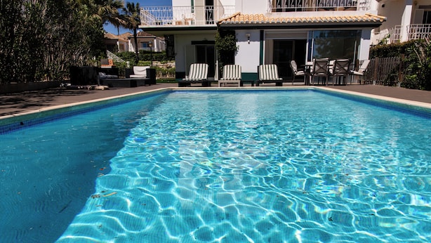 A clear swimming pool with lounge chairs and a patio area. - Encosta do Lago, two suits Finest Apartment with Private Pool and garden. (Almancil)