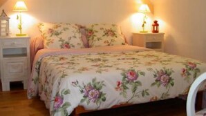 A bedroom with a bed, two bedside tables, and two wall-mounted lamps. - Country Cottage / Gite - SCHERWILLER (Scherwiller)