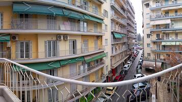 A multi-story residential building with balconies, air conditioning units, and a narrow street between the buildings.