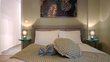 A neatly made bed with patterned bedding, two bedside tables with lamps, and a large abstract painting on the wall.