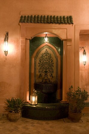 A traditional entrance with a tiled roof, a decorative archway, and two wall-mounted lights. - Jewel of a private home all to yourselves in the heart of the Old City (Marrakech)
