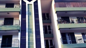 A multi-story building with balconies, a central stairwell, and a modern architectural design. - Madeira Funchal Gardens (Funchal)