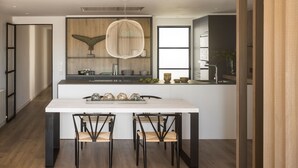A modern kitchen with a central island, wooden cabinetry, and a large window.