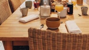 A dining area with a wooden table set for breakfast, surrounded by wicker chairs. - House / Villa - VILLANOVA (Villanova)
