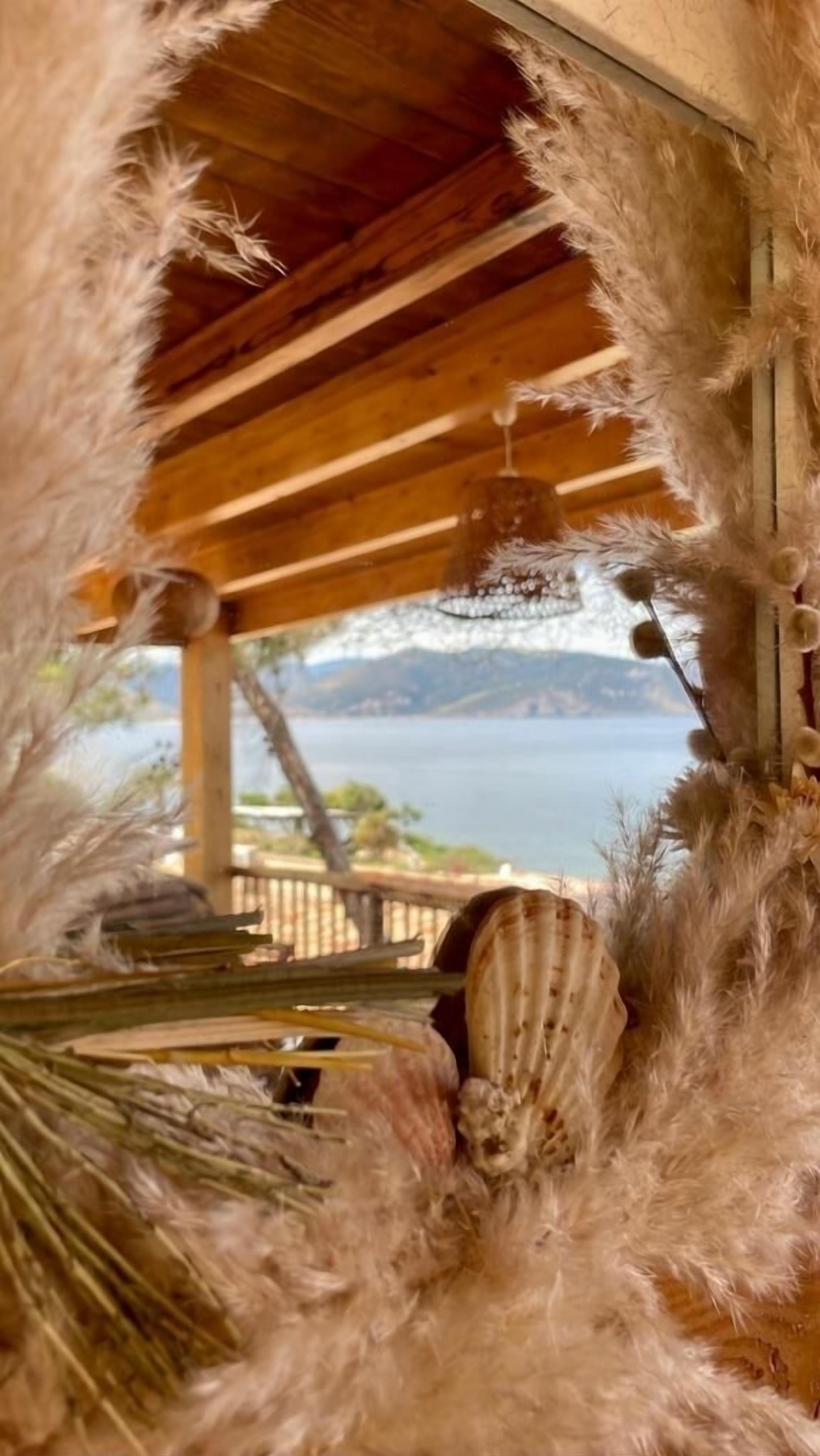 Una construcció de fusta amb vista a un cos d'aigua i muntanyes al fons.