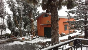 A courtyard with a snow-covered ground, a brick pathway, and a building with an orange facade. - Villa Raffaela - Stately home, independent, quiet, sunny, ideal for a relaxing holiday (Ercolano)