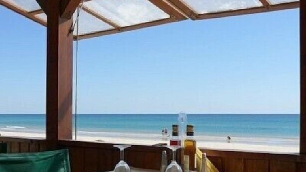 A table set for two with a view of the beach.