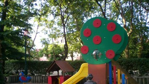 A playground with a slide, climbing structures, and a swing set.