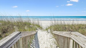 A wooden boardwalk leading to a beach with clear skies. - Isle Of Palms, Luxury Oceanfront Home with Hot Tub (NORTH MYRTLE BEACH)