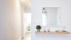 A hallway with a wooden shelf holding a plant, a glass, and a tray with reed diffusers. - Home2Book Vibrant & Trendy Apt Santa Cruz Center (Santa Cruz de Tenerife)