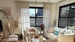 A modern living room with a sofa, a coffee table, and a decorative vase with flowers. - Single-storey house, close to the port and Kerdéniel beach. (Ploudalmézeau)