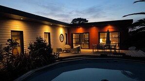 A modern house with a swimming pool, outdoor seating, and a well-lit entrance. - Single-storey house, close to the port and Kerdéniel beach. (Ploudalmézeau)