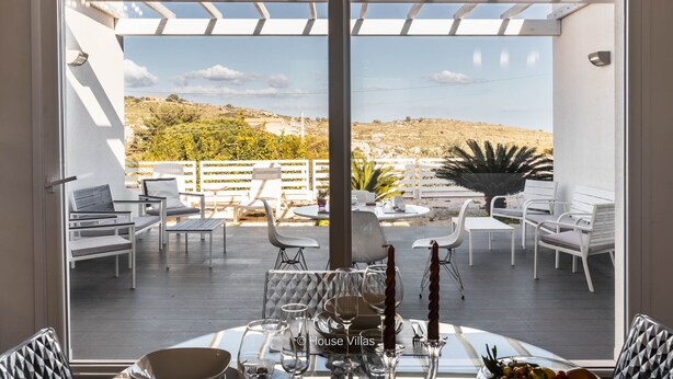 A terrace with a table set for dining, white furniture, and a view of the countryside. - IN AVOLA, BETWEEN NOTO AND SIRACUSA, NEW VILLA WITH PRIVATE POOL (Avola)