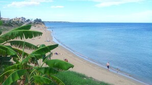 A beach with people sunbathing and swimming, surrounded by greenery and houses in the background. - IN AVOLA, BETWEEN NOTO AND SIRACUSA, NEW VILLA WITH PRIVATE POOL (Avola)