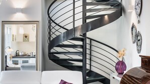 A modern interior with a spiral staircase, a white sofa, and a wooden cabinet. - IN AVOLA, BETWEEN NOTO AND SIRACUSA, NEW VILLA WITH PRIVATE POOL (Avola)