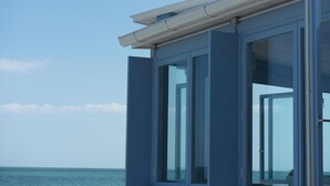 Ein modernes Gebäude mit großen Fenstern und Blick auf ein ruhiges Meer.