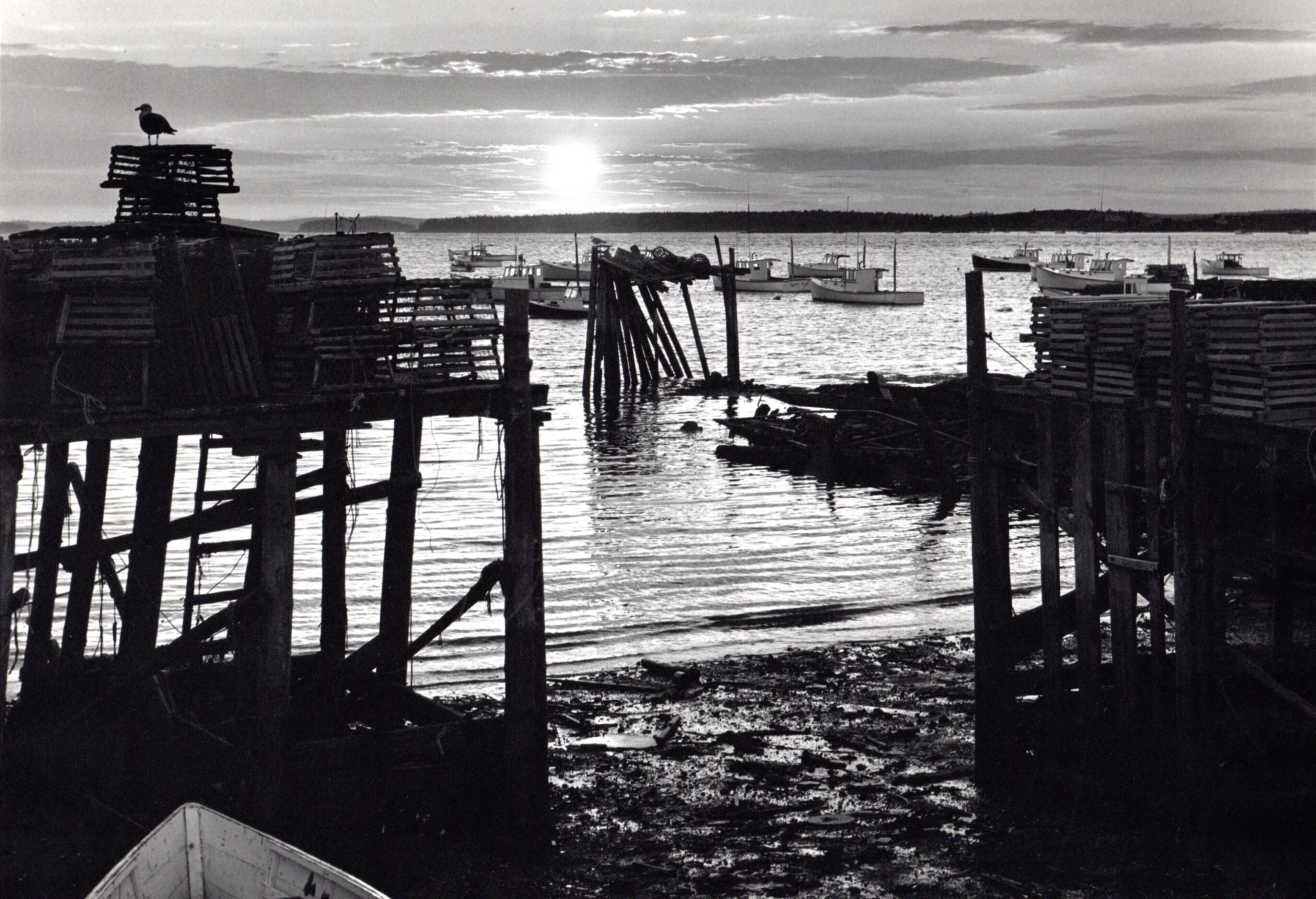 A pier with wooden structures and boats in the water.