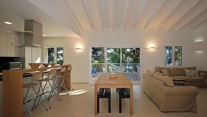 Un espacio habitable moderno con cocina, comedor y sofá.