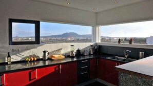 Une cuisine moderne offrant une vue sur le paysage urbain et les montagnes.