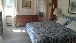 A bedroom with a bed, dresser, and a window with curtains. - Pet Friendly Home, Short Walk to the Beach! (1807) (Wellfleet)