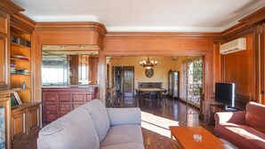 A spacious living room with a large sectional sofa, a wooden coffee table, and a television. - Bed&BCN Hills House with swimming pool (Barcelona)