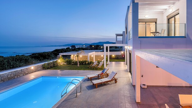 A modern poolside area with a clear view of the sea, a pool, and lounge chairs. - Sea La vie Villa in Kiotari (RHODES)