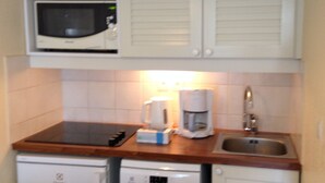 Une cuisine équipée d’un four à micro-ondes, d’une machine à café et d’un lave-vaisselle.
