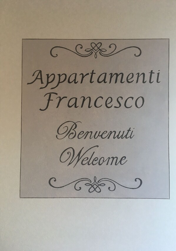 A welcome sign with the text "Appartamenti Francesco Benvenuti Welcome".