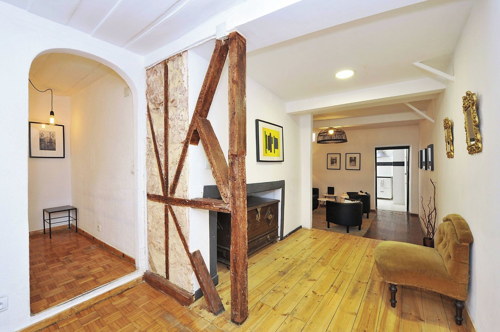 A spacious living area with a wooden floor, a fireplace, and a sofa.