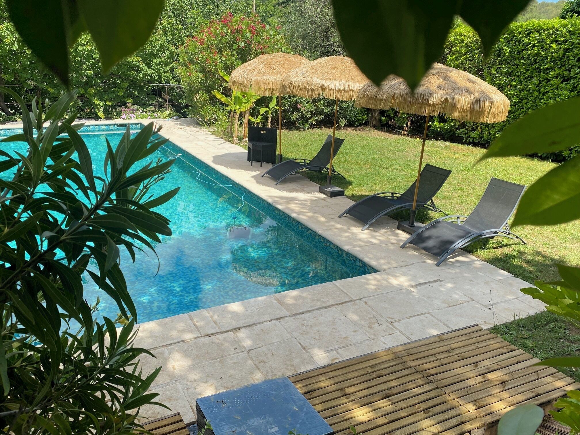 A swimming pool with lounge chairs and thatched umbrellas.