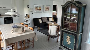 A cozy living room with a dining table, sofa, and a vintage cabinet. - Holiday house close to the beach  (Hundested)