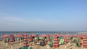 A beach with striped umbrellas and green lounge chairs. - Very private, spacious, rural, detached villa with a pool, nestled between the sea and the mountains (Monte San Pietrangeli)
