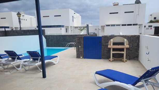 A rooftop pool area with lounge chairs, a barbecue grill, and a stone wall. - Semi-detached Villa, 2 bedrooms, 2 bathrooms, private pool, WiFi, parking (Playa Blanca)