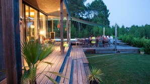 A wooden deck with outdoor seating and a glass-enclosed room. - BRIGHT 250m² ARCHITECT-DESIGNED VILLA OPEN TO THE OUTDOORS WITH PRIVATE POOL (Messanges)