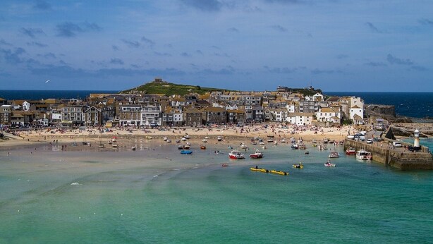 A coastal town with a historic fort on a hill, a sandy beach, and a marina with boats. - Mousehole Cottage: sea views, parking & close to village centre, dog friendly. (Mousehole)