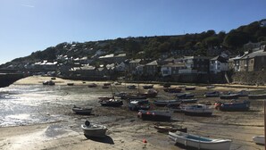 A beach with boats and houses in the background. - Mousehole Cottage: sea views, parking & close to village centre, dog friendly. (Mousehole)