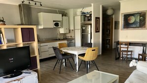 A compact living space with a dining area, kitchenette, and a television. - Sorry, not available this year - Sorry, apartment not available this year. (Antibes)