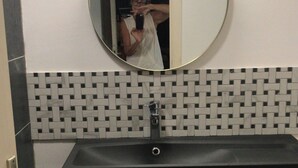 A bathroom with a round mirror, a black sink, and a wooden vanity. - Sorry, not available this year - Sorry, apartment not available this year. (Antibes)