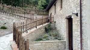 A stone building with a wooden staircase leading to a balcony. - Colle di Pietra - Colle di PIetra (Cessapalombo)